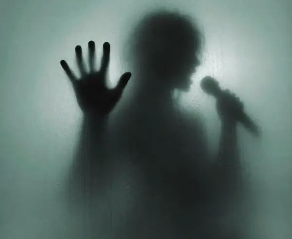 Shadowy figure behind misted glass